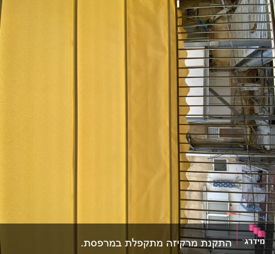 סוכך צהוב עם קפלים על מרפסת
